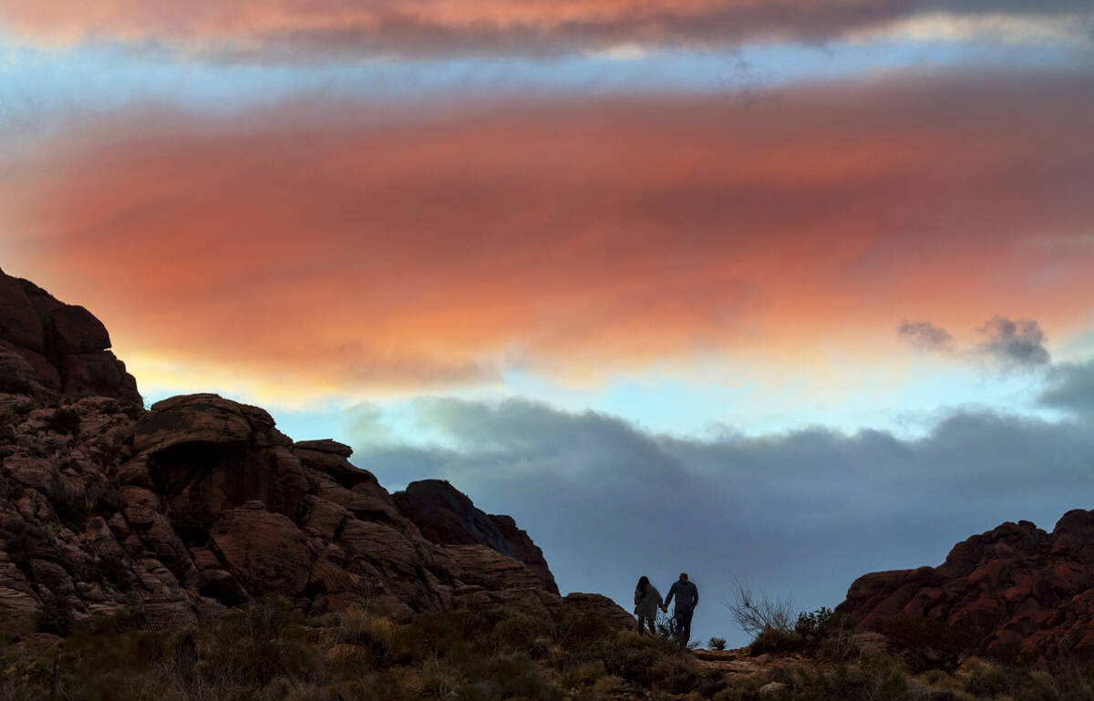 A couple walk up a path in the sunset at Red Springs within the Red Rock Canyon National Conser ...