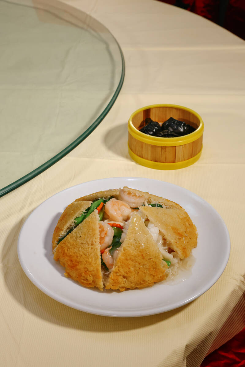 The fried crisp rice noodles, front, and squid ink and chive dumplings at Ellie’s Chinese Res ...