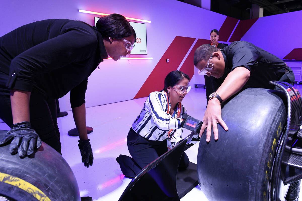 Karen Osorio is assisted by Nette Buchanan, left, and Angel Suero as she takes part in a pit st ...