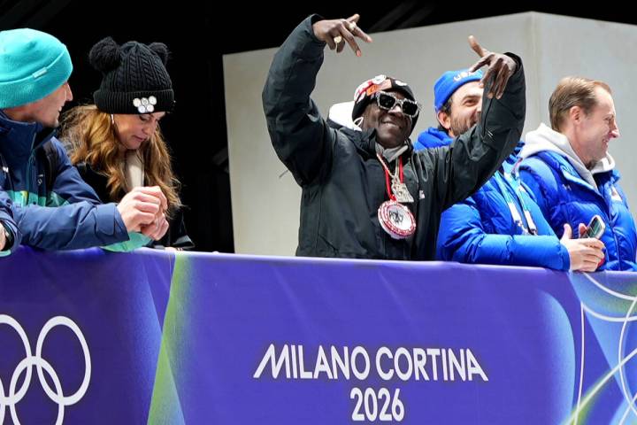 American rapper Flavor Flav, center, attends the skeleton mixed team competition at the 2026 Wi ...