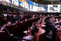 Guests watch on the big screens the first day of the NCAA basketball tournament at the Sports B ...