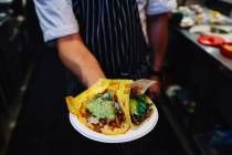 Chef Jorge Alvarez-Tostado holds up tacos at Tacos 1986 at The Neighborhood Food Hall in the Re ...