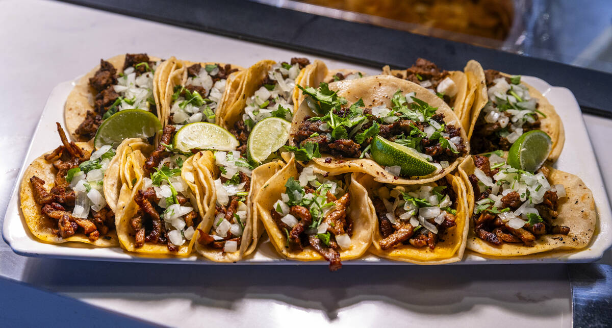 Executive Chef Antonio Coleman prepares a plate of al pastor, chicken and carne asada tacos as ...