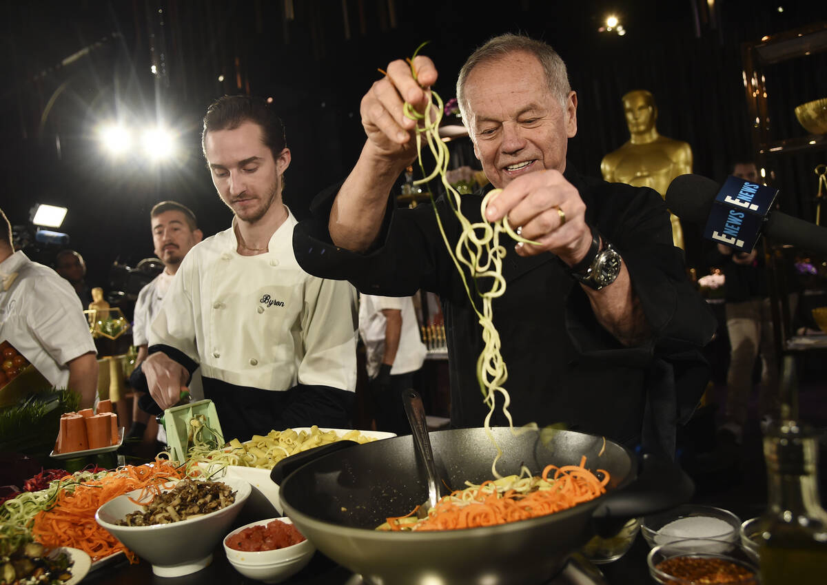 FILE - Chef Wolfgang Puck right, and his son Byron make a pasta dish at the Governors Ball Pres ...