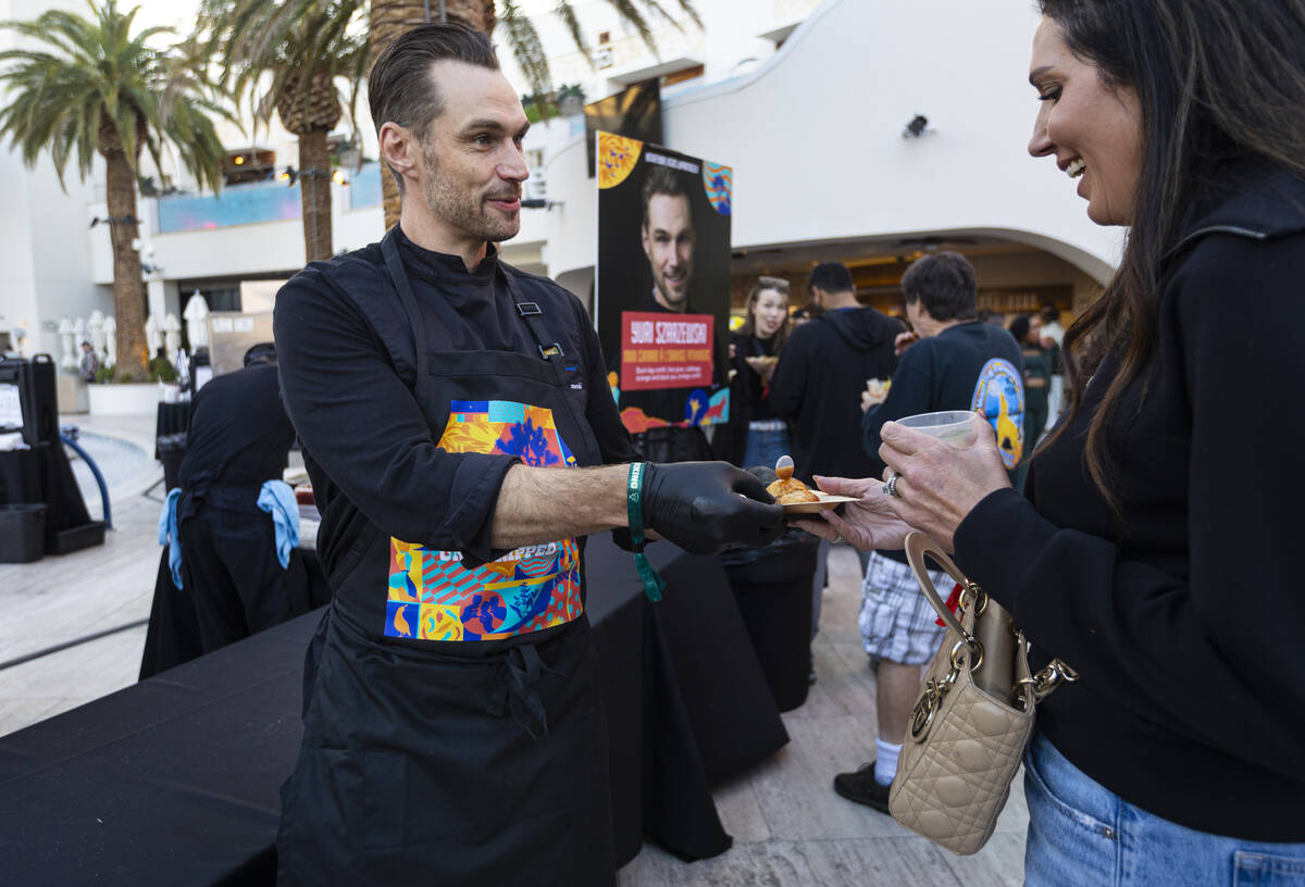 Chef Yuri Szarzewski of Partage hands out dishes with duck leg confit, foie gras, cabbage, oran ...
