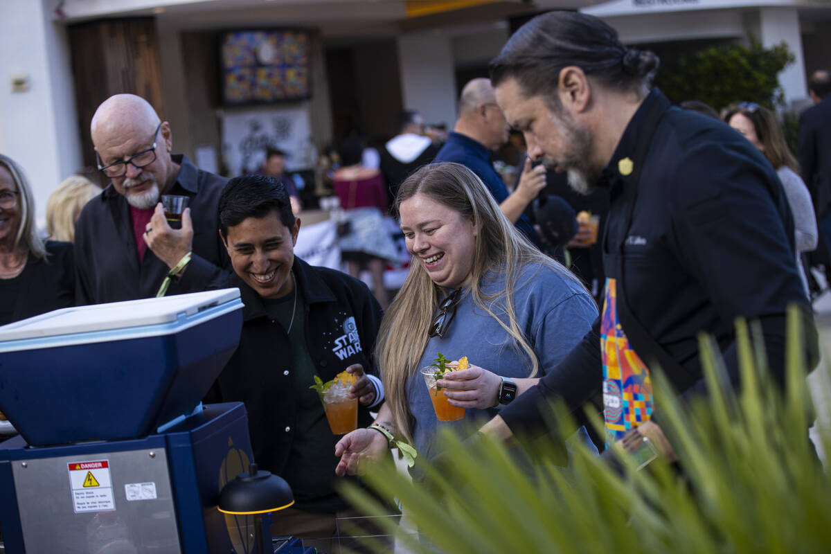 Attendees react as Chef Gary LaMorte prepares blue crab & smoked garlic handrolls with avoc ...