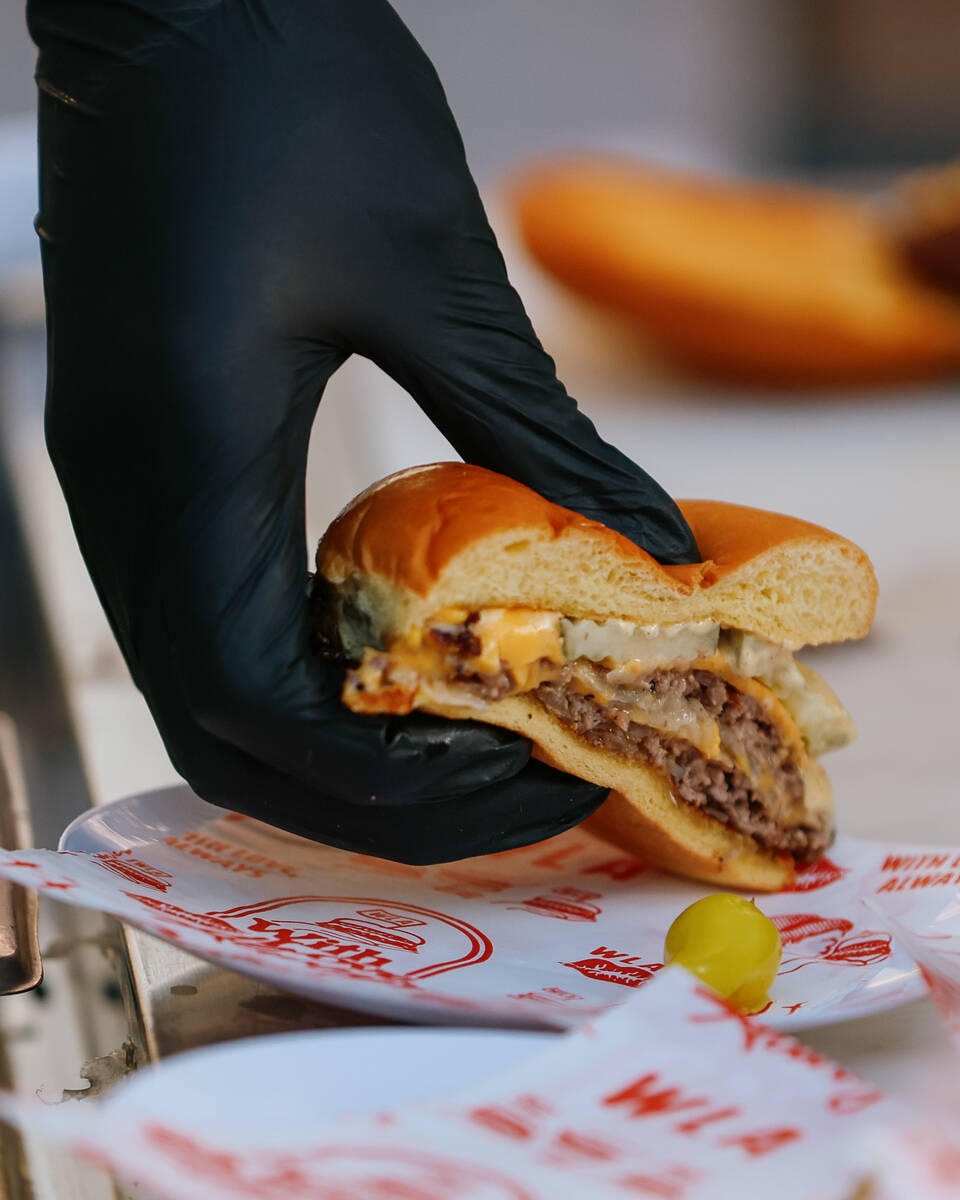 A smashed onion burger from With Love, Always is prepared for waiting guests during the Taste o ...