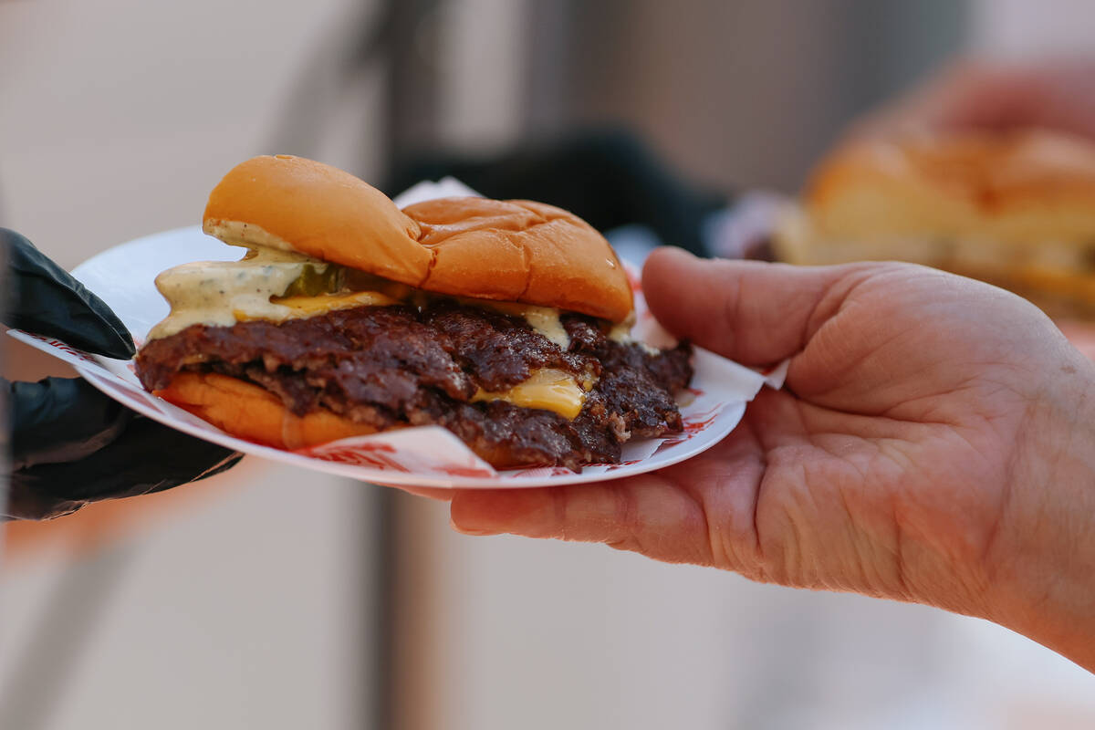 A smashed onion burger from With Love, Always is prepared for waiting guests during the Taste o ...