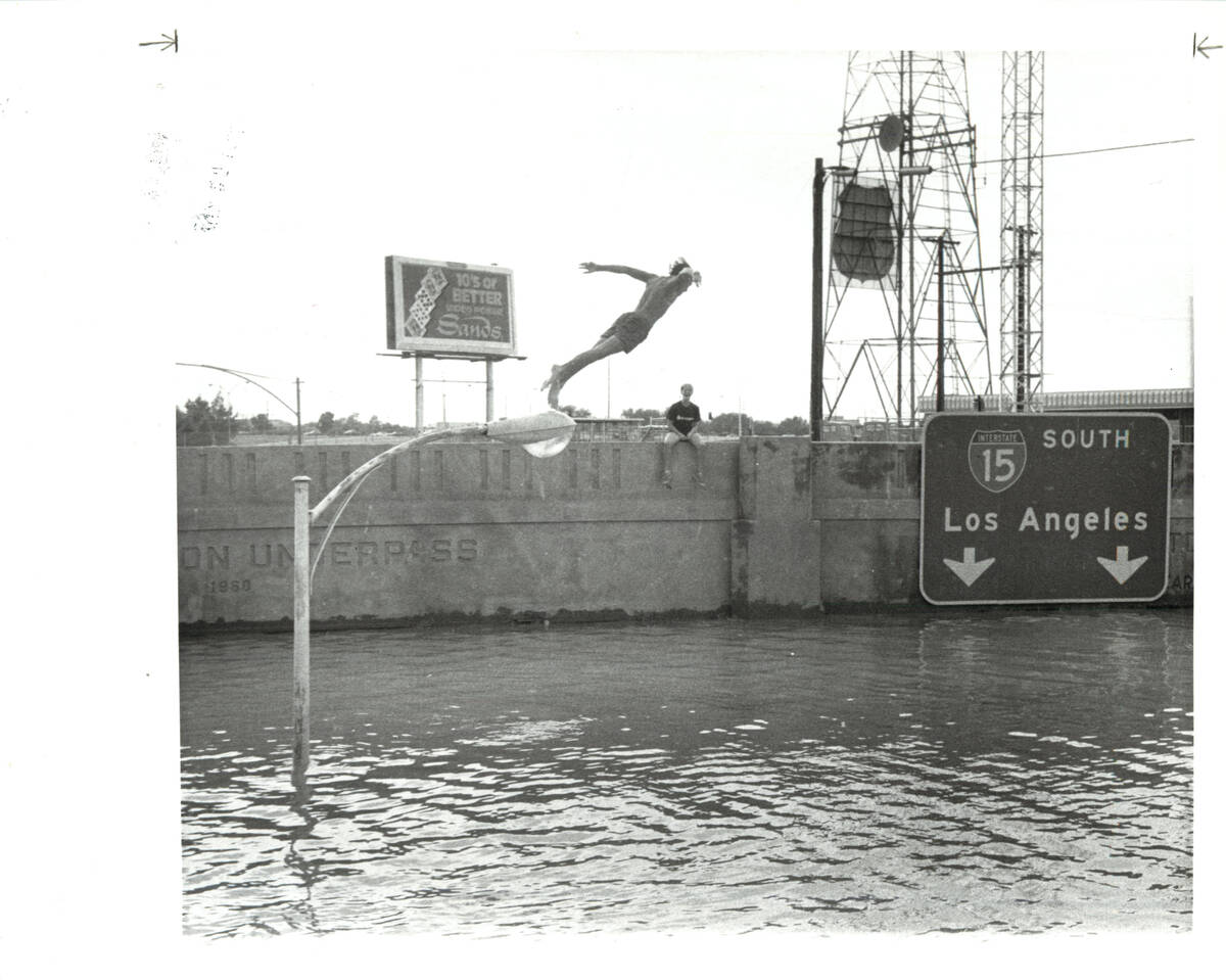 A man dives off a light fixture into flood water in the summer of 1984 along the Charleston Bou ...
