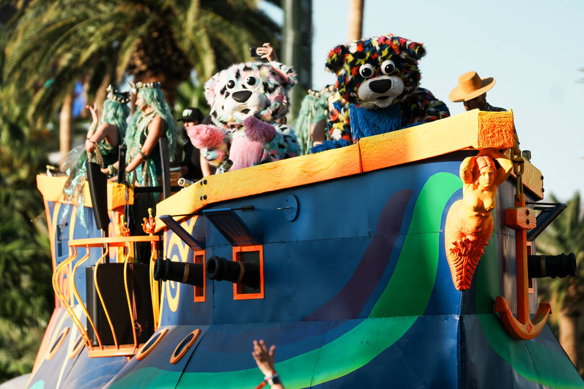 World Party Parade performers wave to the audience while atop a boat shaped parade float during ...