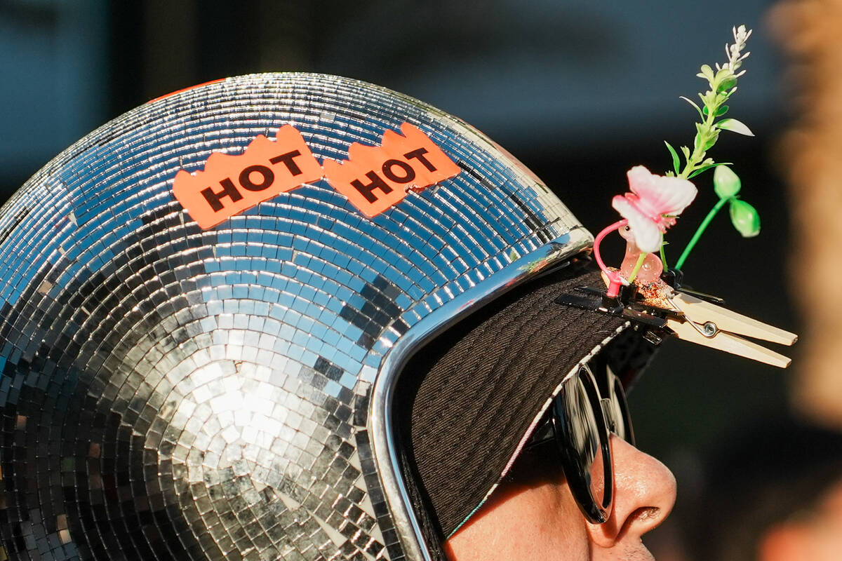 World Party parade goer looks ahead while wearing a disco ball helmet with sprouts mounted on i ...