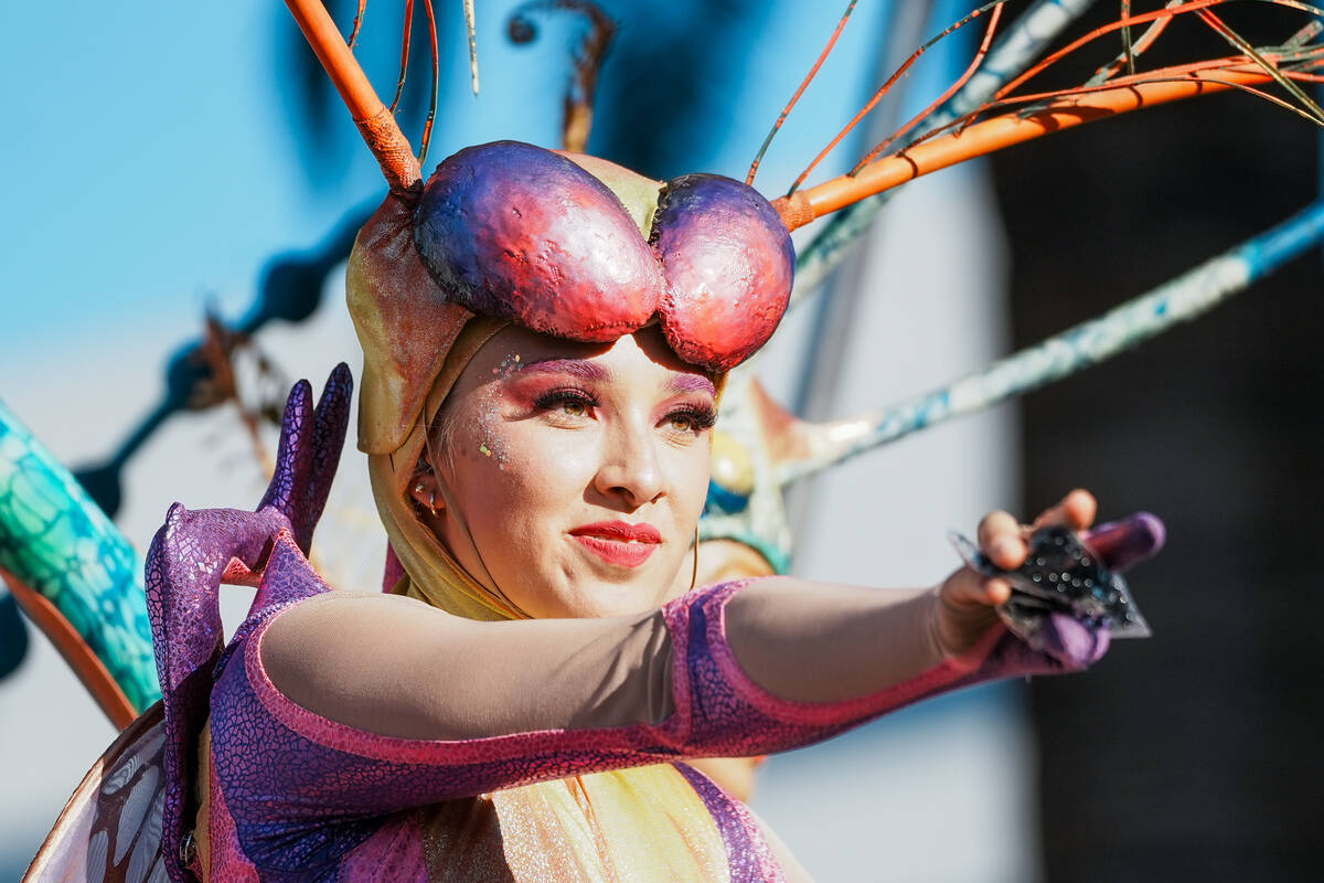 World Party Parade performer dressed as a bug smiles towards the audience during debut of an El ...