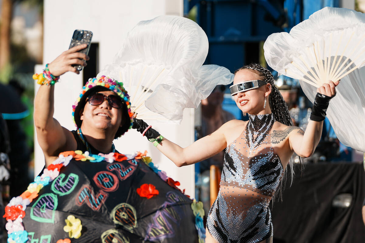 A World Party Parade performer takes a selfie with parade goer Rofolfo Ducay, left, during the ...