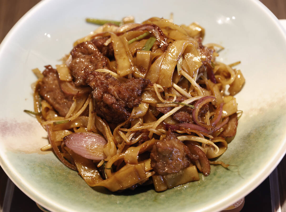 Beef chow fun, a popular Cantonese dish featuring stir-fried, wide, flat rice noodles, is displ ...