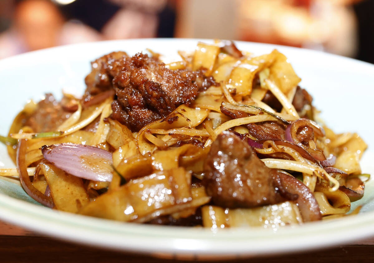 Beef chow fun, a popular Cantonese dish featuring stir-fried, wide, flat rice noodles, is displ ...