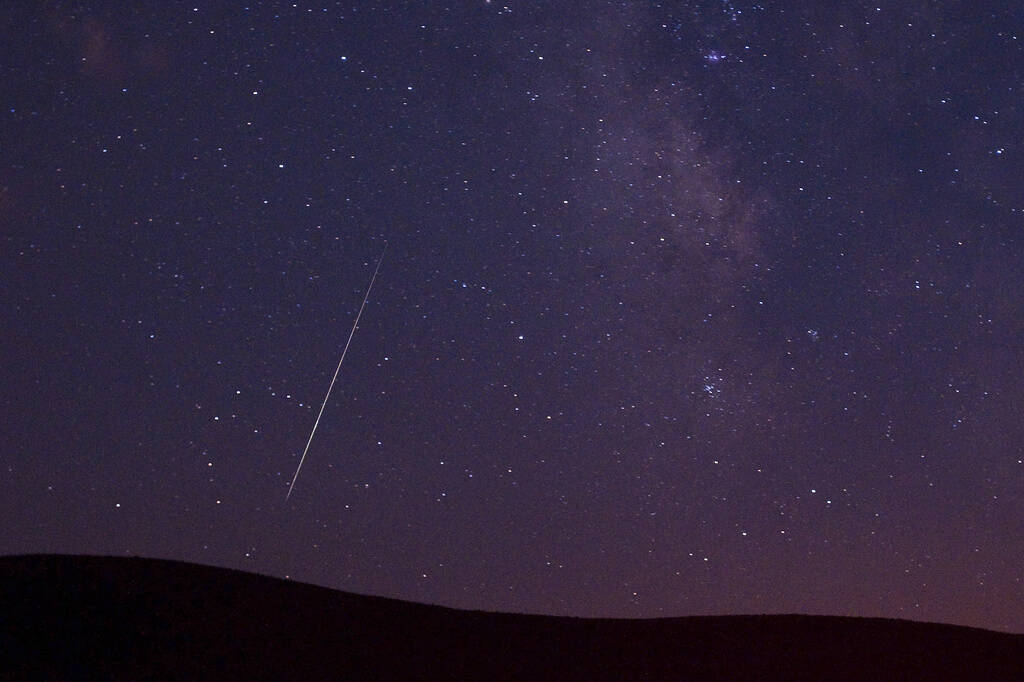 FILE - A Perseid meteor streaks across the sky during the Perseid meteor shower in Vinton, Cali ...