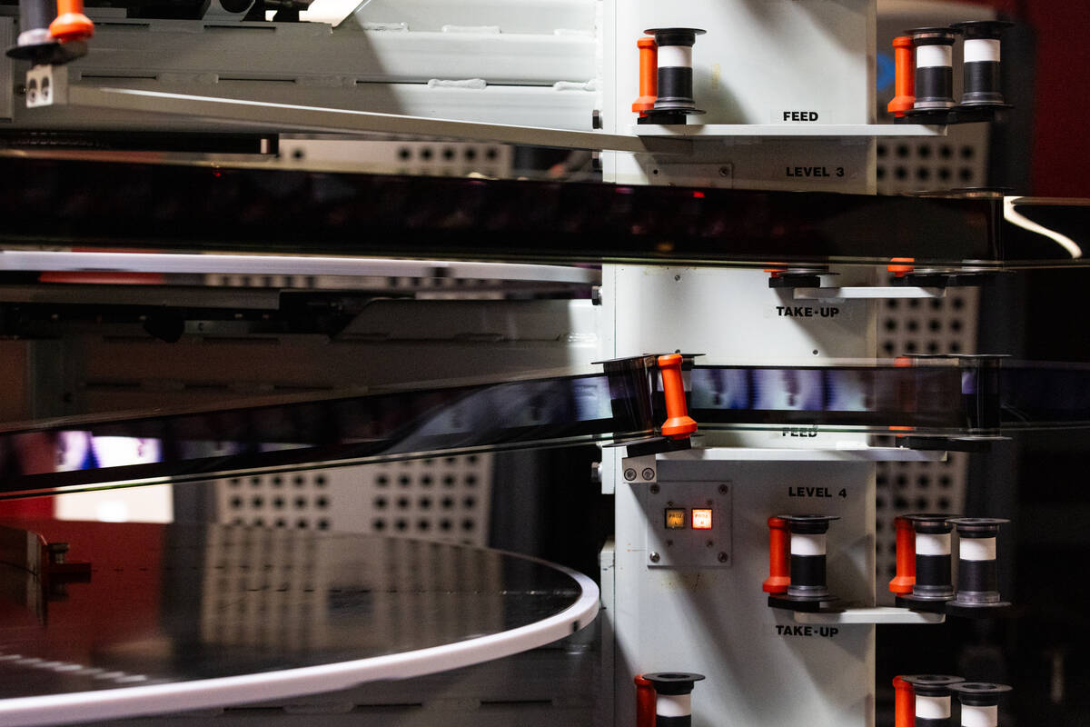 Film for an IMAX projector runs through wheels while testing the system at Brenden Theaters on ...