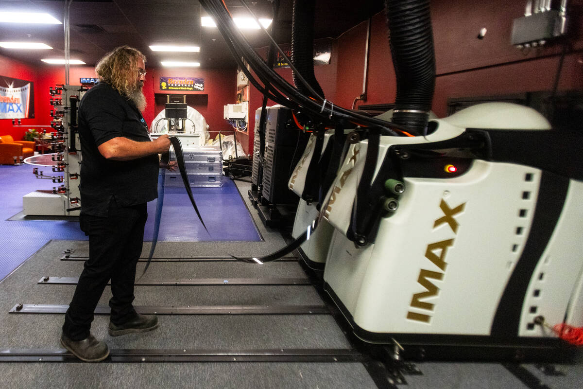 Ted Cotton, an IMAX projectionist “threads up” film for an IMAX projector at Bren ...