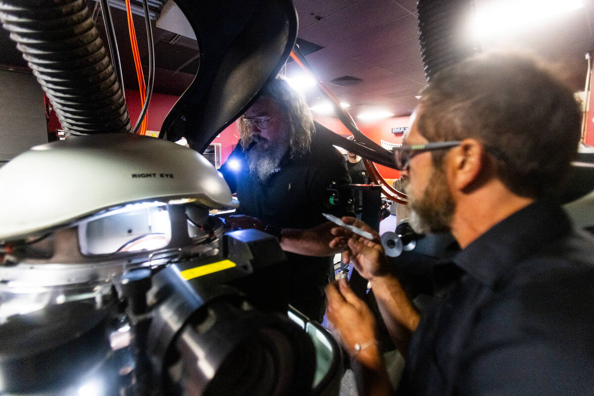 Joshua Shroyer, right, and Ted Cotton, both IMAX projectionists, “thread up” film ...