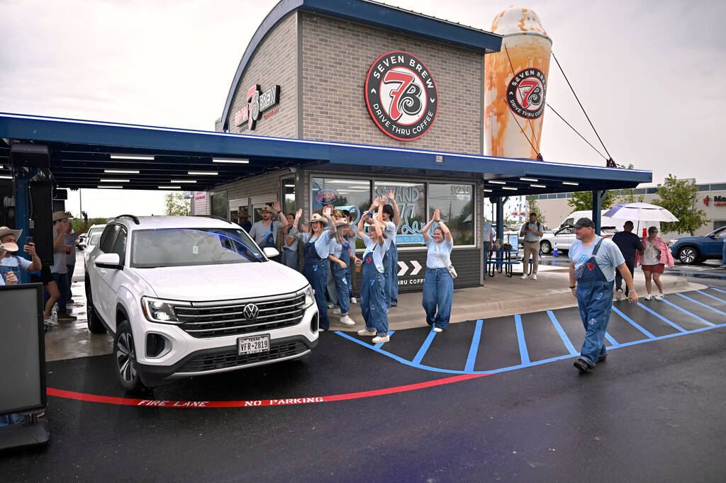 Brew Crew team members celebrate a lucky fan receiving free drinks for one year during 7 Brew's ...