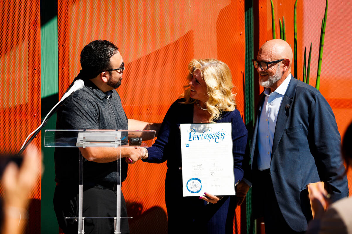 Representative of Commissioner Jim Gibson, Alvaro Lozano, presents the CEO of the Boulder City ...