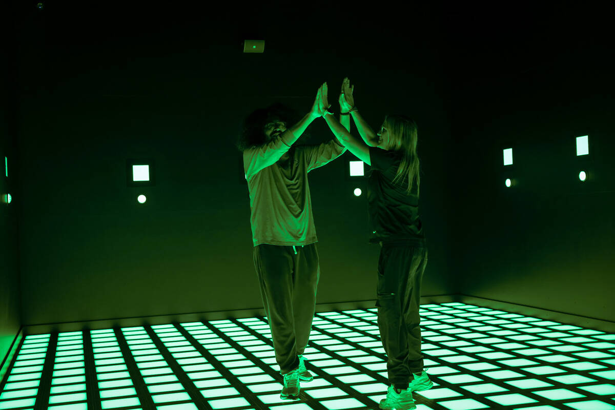 Activate Games staffers high-five each other after demonstrating how the “Mega Grid  ...